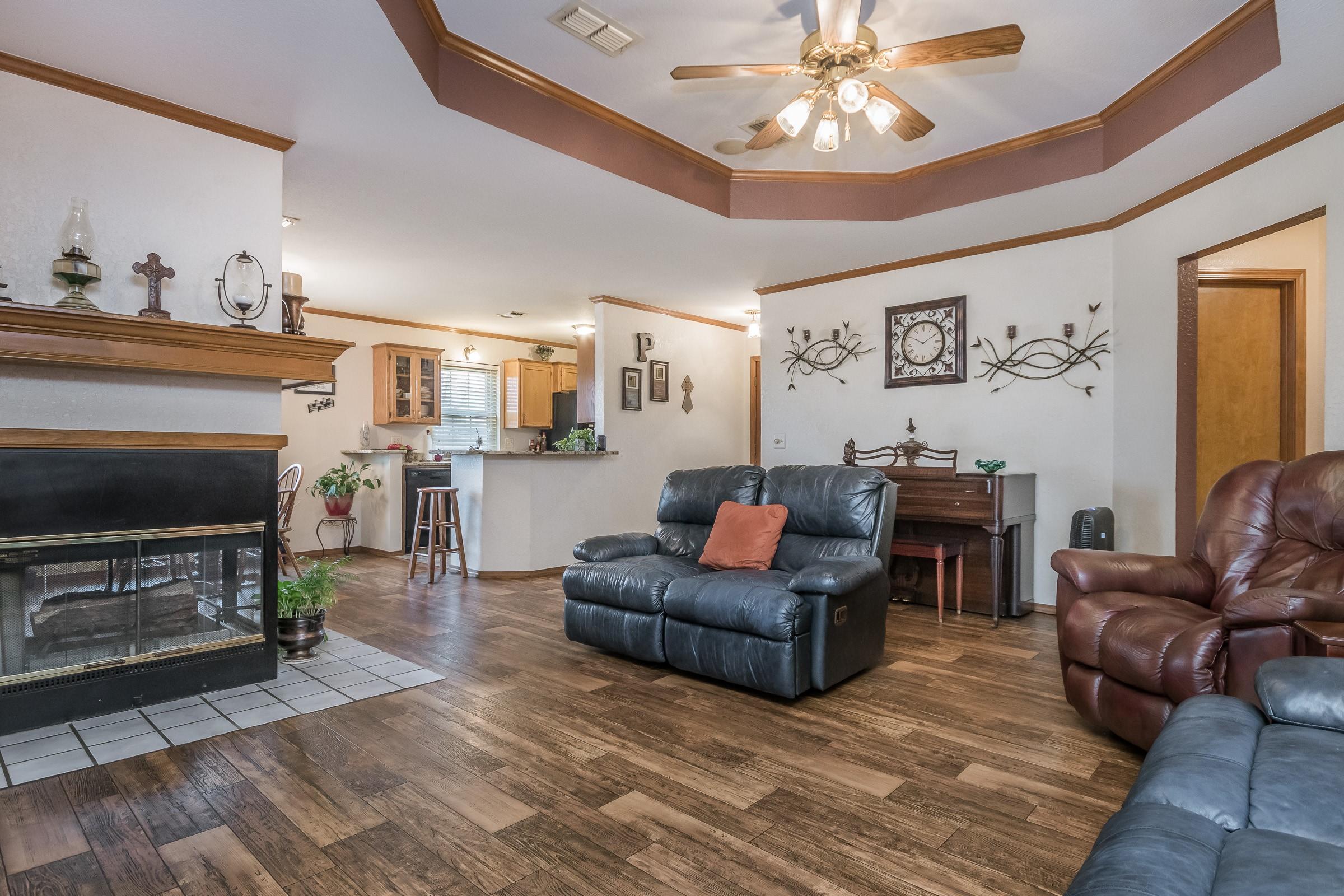 8013 Claret Street Amarillo, TX 79110 - Photo 3 of 19 a living room with furniture a fireplace and a chandelier