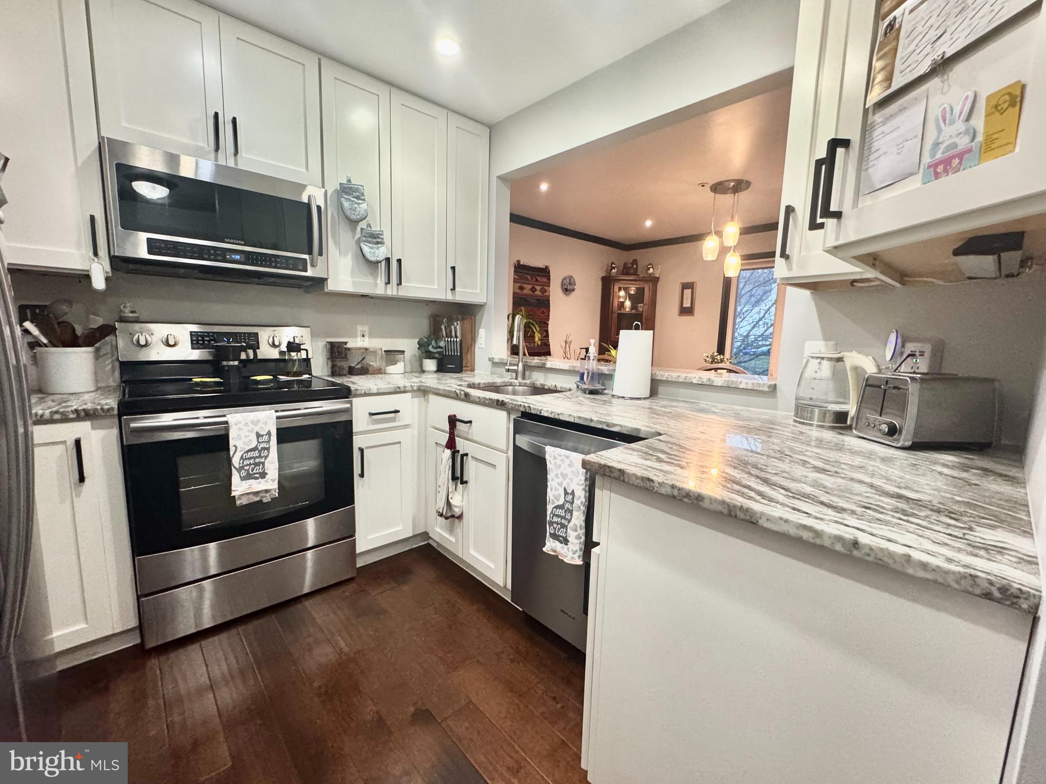 345 Pleasanton Road, Unit A31 Westminster, MD 21157 - Photo 3 of 16 a kitchen with stainless steel appliances granite countertop a stove a sink and a microwave