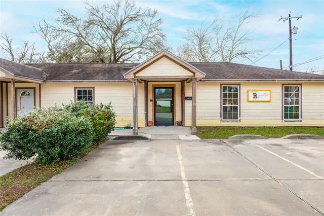 a view of a house with a yard and large tree