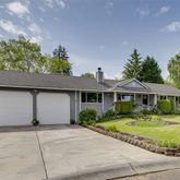a front view of a house with a garden and trees