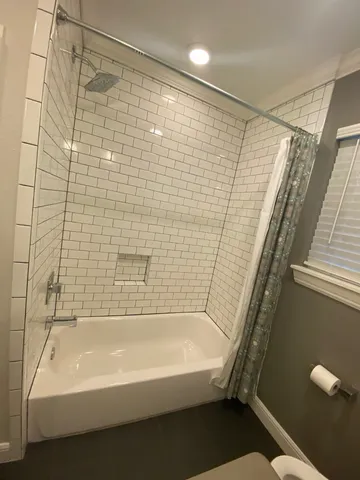 a bathroom with a bathtub and shower