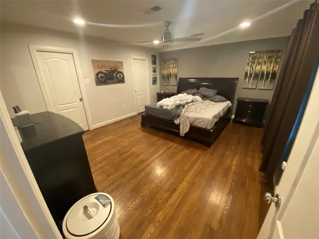 a spacious bedroom with a bed and a dresser with rug