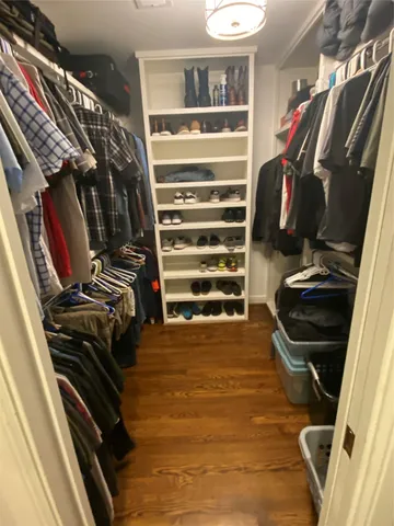 a view of walk in closet with clothes and shoes