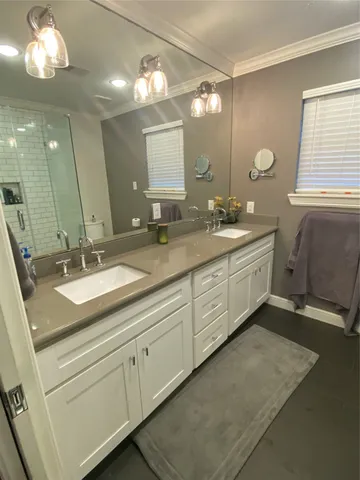 a bathroom with double sink and a mirror