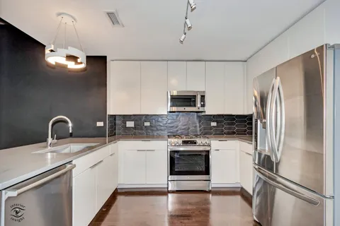 a kitchen with stainless steel appliances a refrigerator sink and microwave