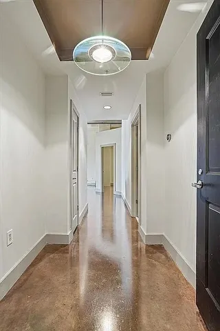 a view of a hallway with wooden floor and a dining room