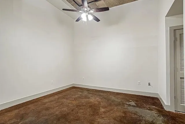 an empty room with a window and ceiling fan