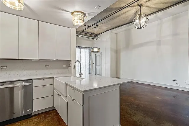 a kitchen with a sink dishwasher and white cabinets with wooden floor