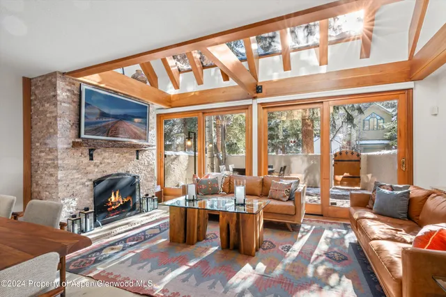 a living room with furniture fireplace and a large window