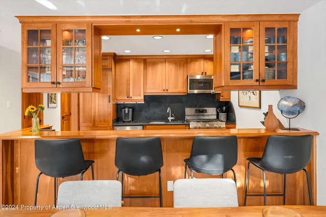 a kitchen with a table chairs and wooden floor
