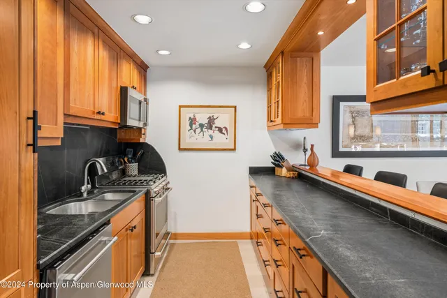 a kitchen with stainless steel appliances a sink stove and cabinets
