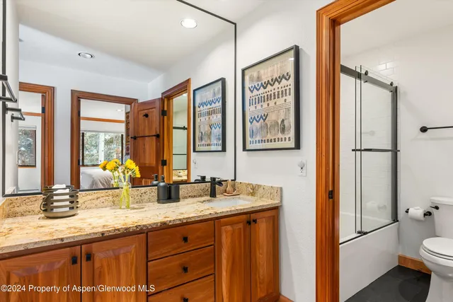 a bathroom with double vanity sink a mirror and a shower