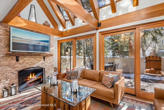 a living room with furniture a fireplace and a floor to ceiling window