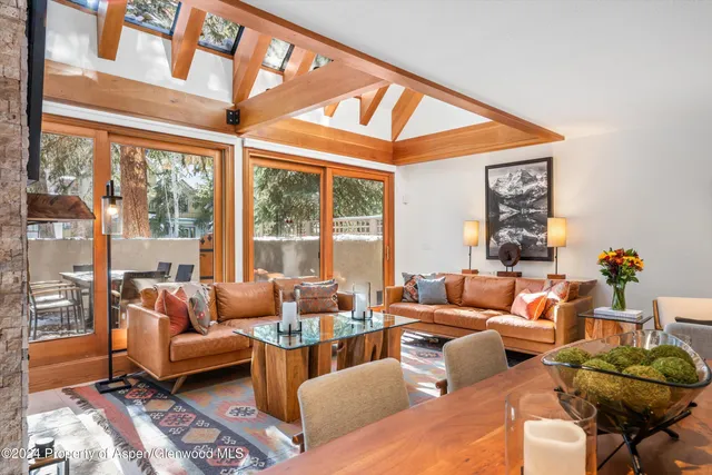 a living room with furniture and floor to ceiling windows