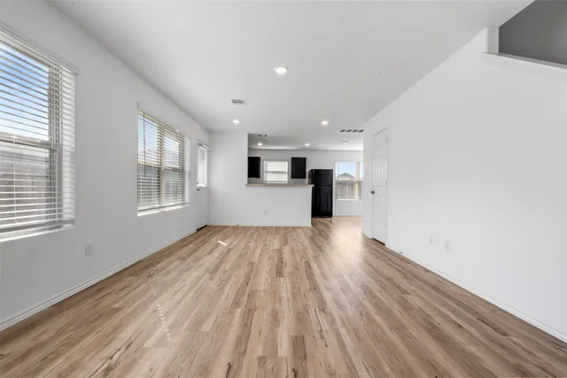 a view of empty room with wooden floor and window