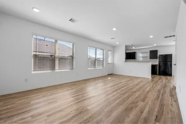 a view of empty room with wooden floor and windows