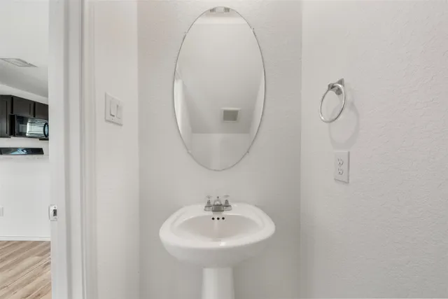 a bathroom with a sink a mirror and a light fixture