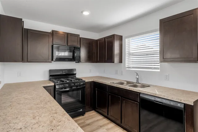 a kitchen with a sink stove top oven and cabinets