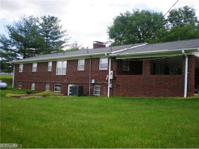8624 Hudson James Road Summerfield, NC 27358 - Photo 14 of 15 Exterior Back. Lower level has private entrance. Originally, there were stairs from the main level leading to the basement. Propane gas is used for gas heater in main level fireplace.