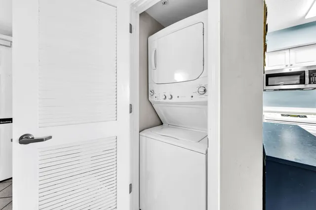 a view of a dining room and livingroom with furniture wooden floor a rug a flat screen tv