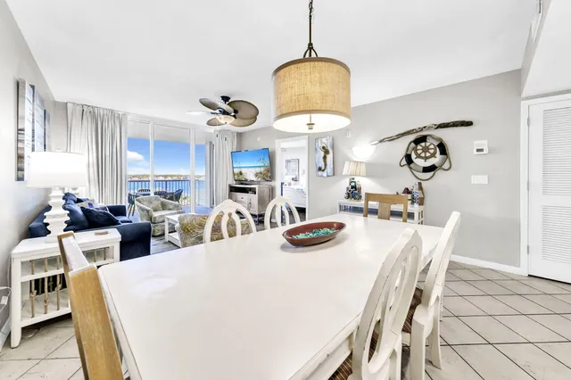 a living room with furniture kitchen view and a large window