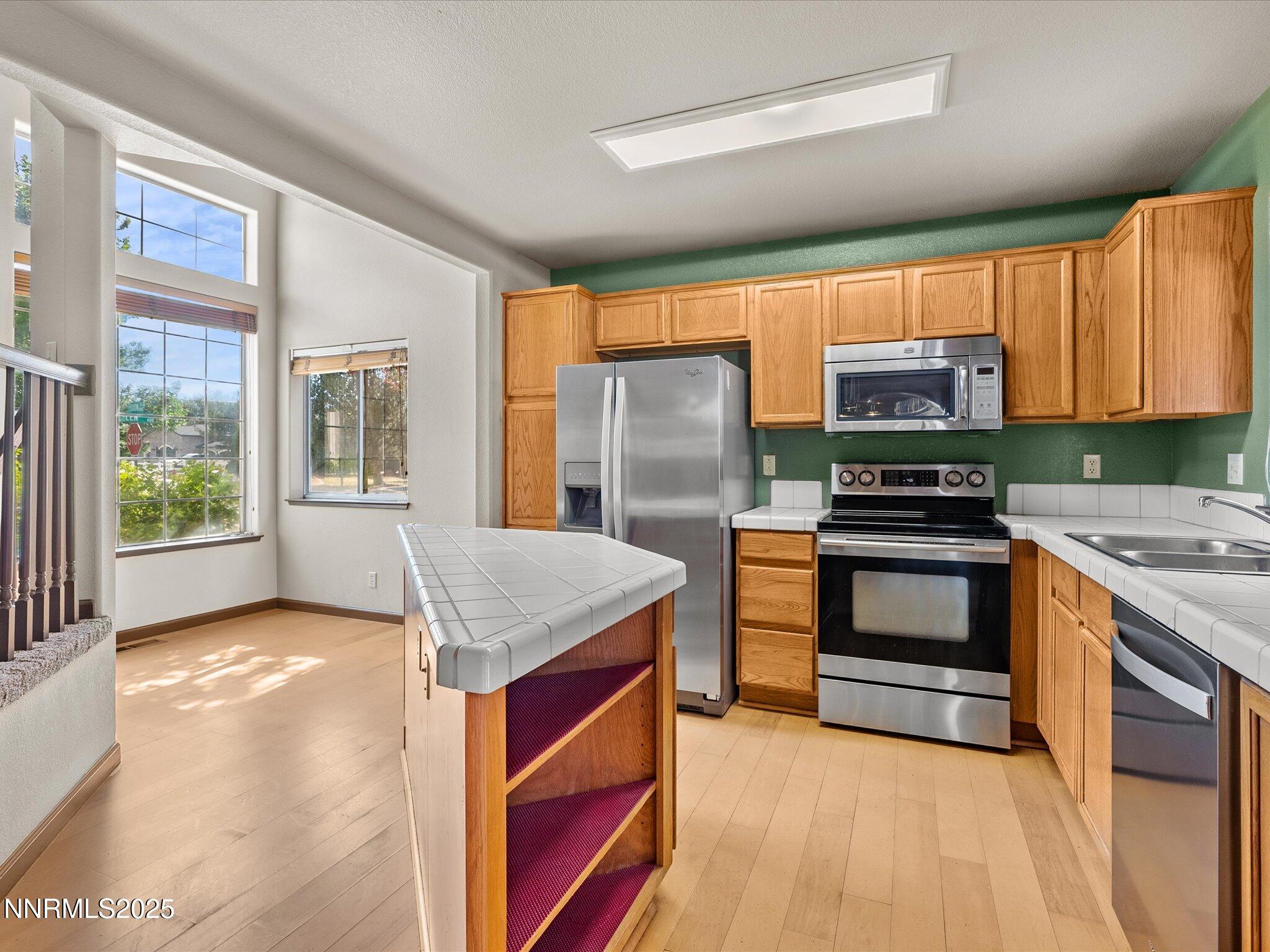 450 Len Circle Reno, NV 89511 - Photo 18 of 44 a kitchen with stainless steel appliances granite countertop a stove a sink and a refrigerator