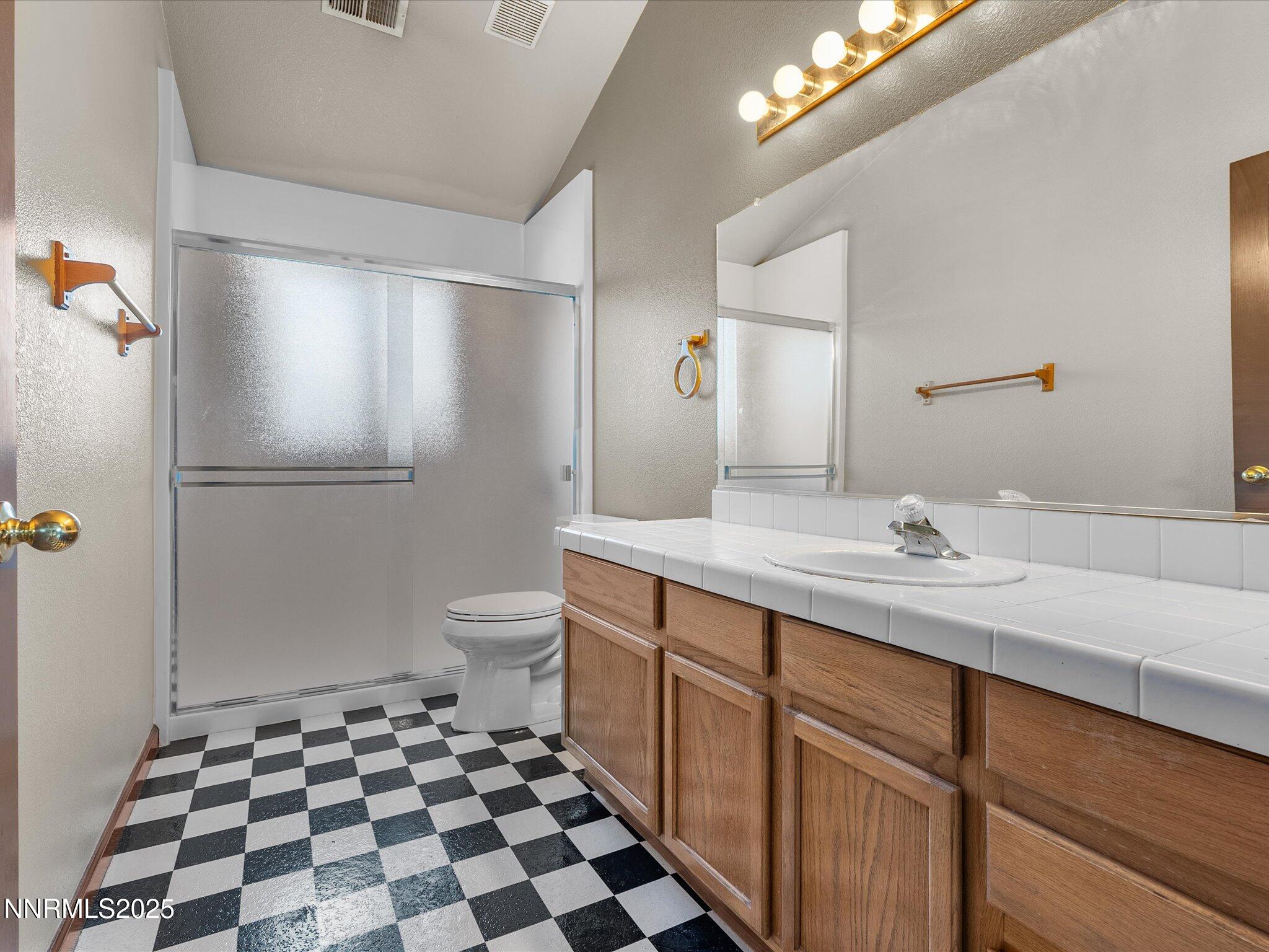 450 Len Circle Reno, NV 89511 - Photo 36 of 44 a spacious bathroom with a double vanity sink toilet and a mirror