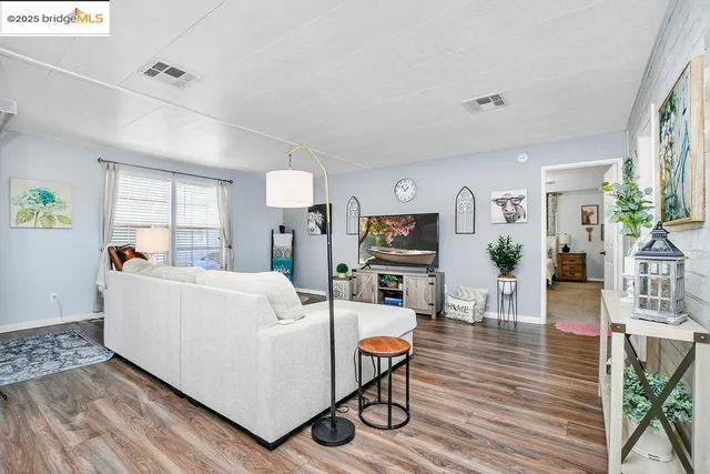 a living room with furniture a flat screen tv and a wooden floor