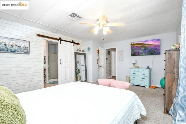a spacious bedroom with a bed and a cabinets