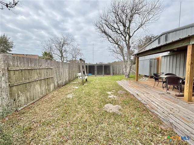 a view of a backyard with table and chairs under an umbrella