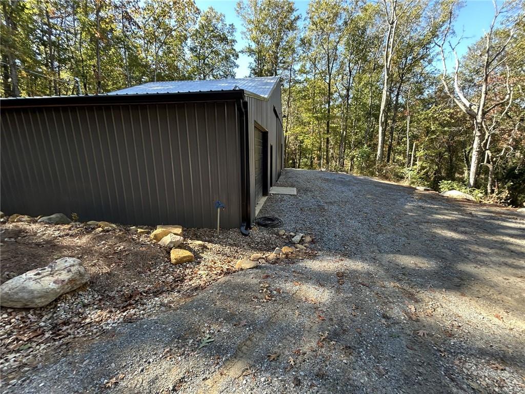 5997 Henderson Mountain Road Jasper, GA 30143 - Photo 6 of 11 a backyard of a house with large trees and wooden fence