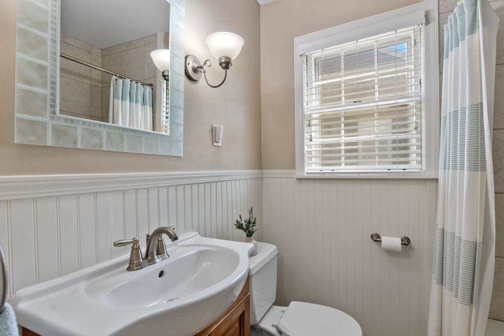 5580 Normandy Road Memphis, TN 38120 - Photo 18 of 25 a bathroom with a sink a mirror and a toilet