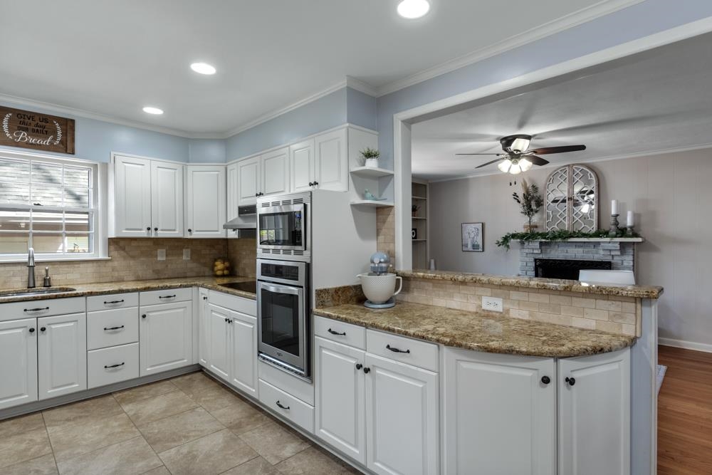 5580 Normandy Road Memphis, TN 38120 - Photo 7 of 25 a kitchen with granite countertop stainless steel appliances a sink stove and refrigerator