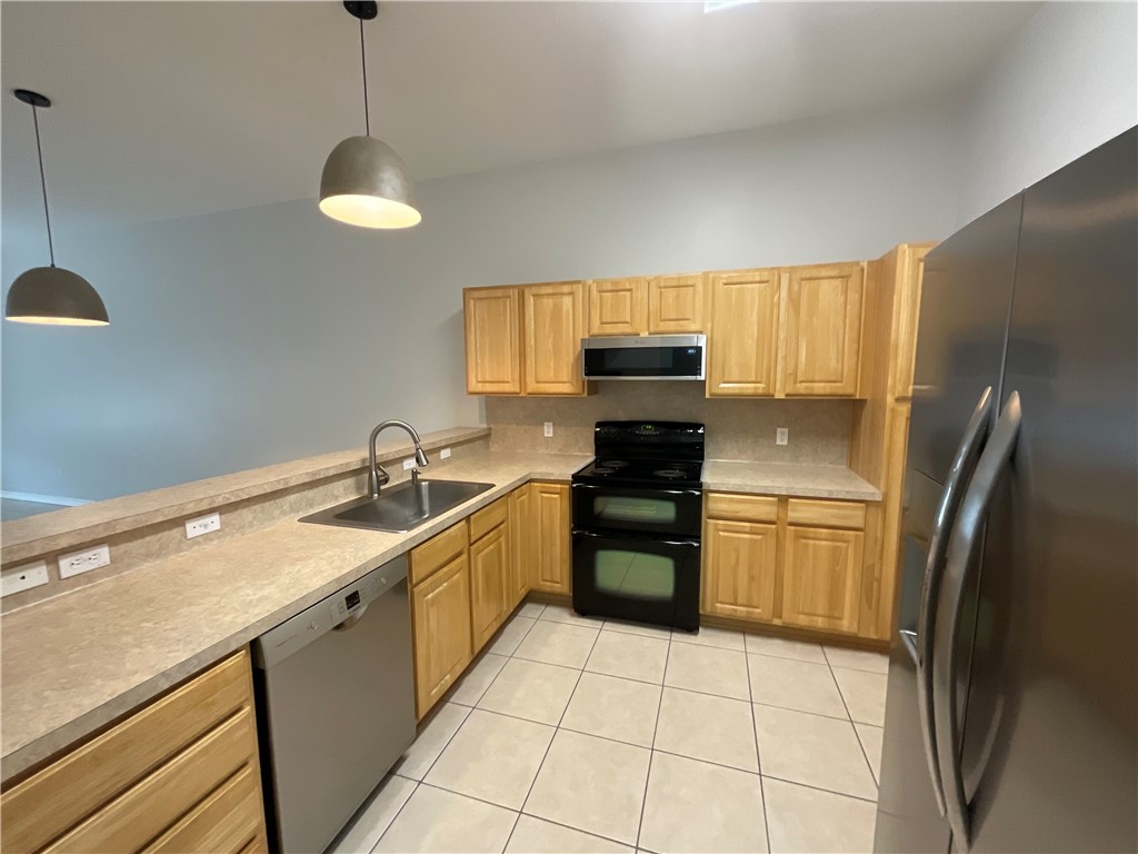 15330 Cruiser Street, Unit A Corpus Christi, TX 78418 - Photo 5 of 20 a kitchen with stainless steel appliances a sink dishwasher a refrigerator and a stove