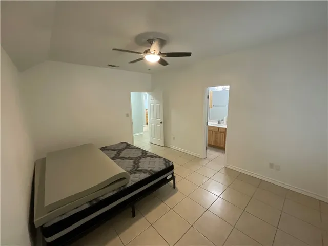 a room with a bed and ceiling fan