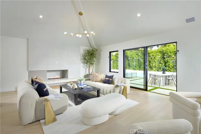 a kitchen that has a lot of white cabinets and stainless steel appliances