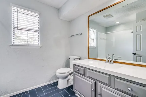 a bathroom with a sink toilet and mirror