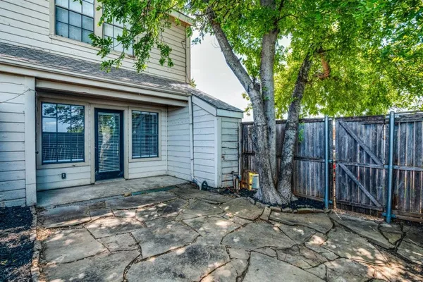 a view of a house with backyard and wooden fence