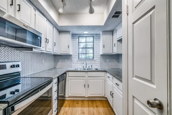 a kitchen with a sink stove and cabinets