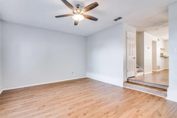 an empty room with wooden floor and door