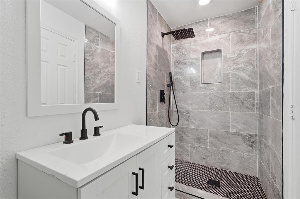 10332 Muskogee Circle Dallas, TX 75217 - Photo 20 of 39 a bathroom with a shower sink and mirror