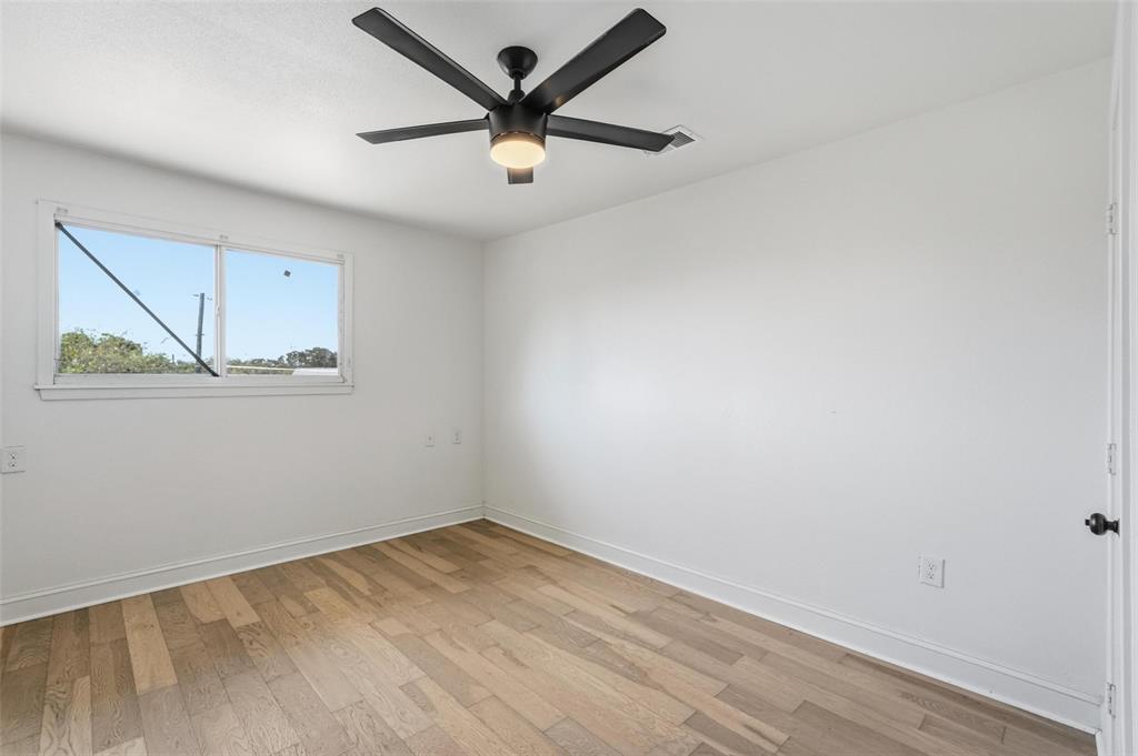 10332 Muskogee Circle Dallas, TX 75217 - Photo 24 of 39 an empty room with wooden floor and windows