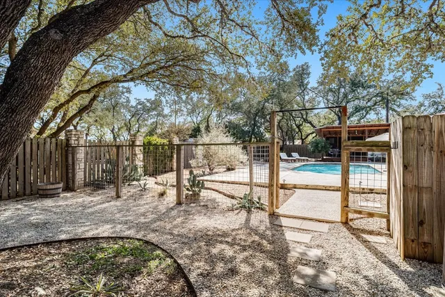 a view of a patio with table and chairs with wooden floor and fence
