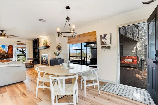 a view of a dining room and livingroom with furniture wooden floor a chandelier