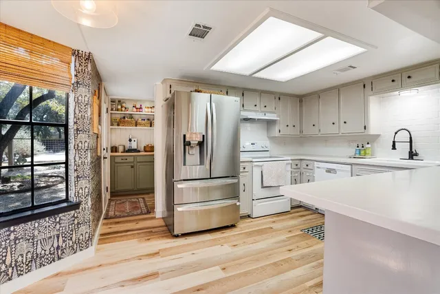 a kitchen with white cabinets and stainless steel appliances