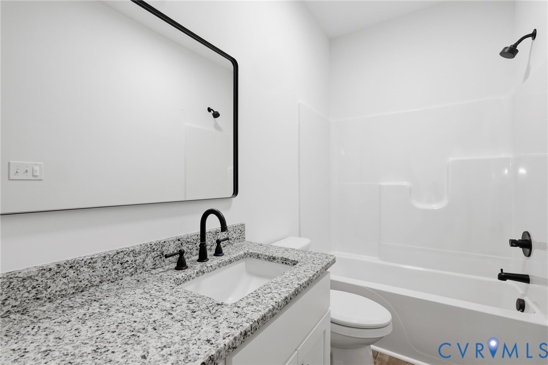 2255 Bagby Road Bumpass, VA 23024 - Photo 27 of 30 a bathroom with a granite countertop sink toilet and shower