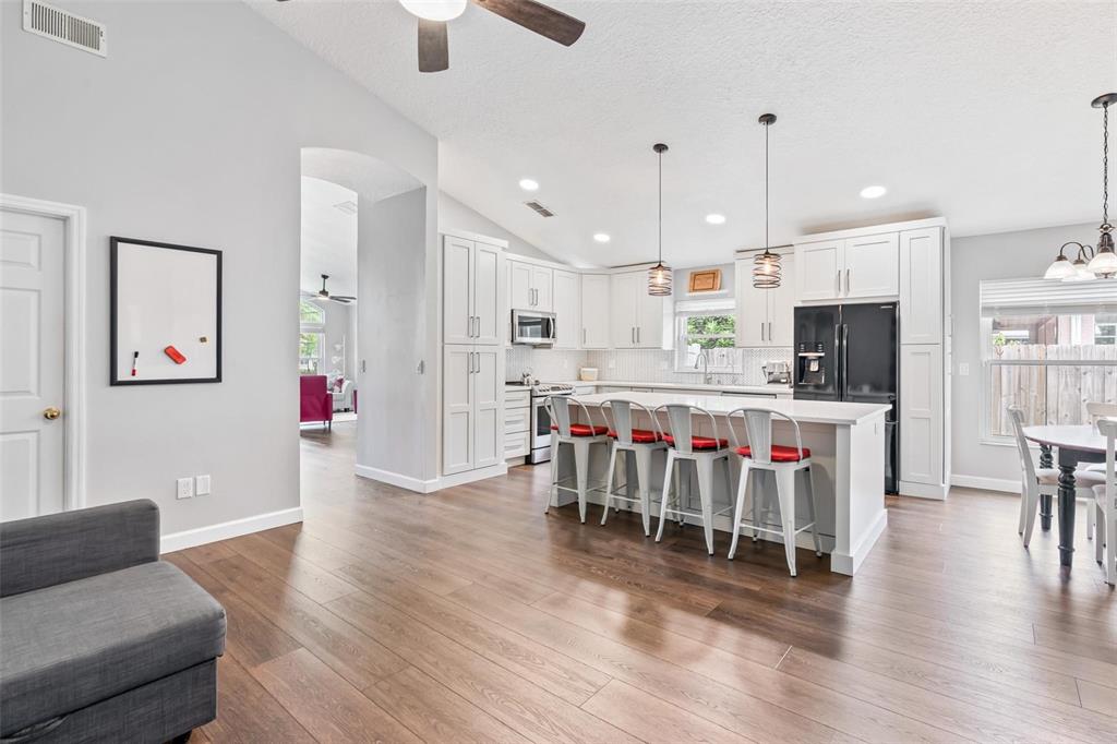 325 Longshadows Court Ocoee, FL 34761 - Photo 11 of 34 a kitchen with stainless steel appliances kitchen island granite countertop a dining table chairs and view living room