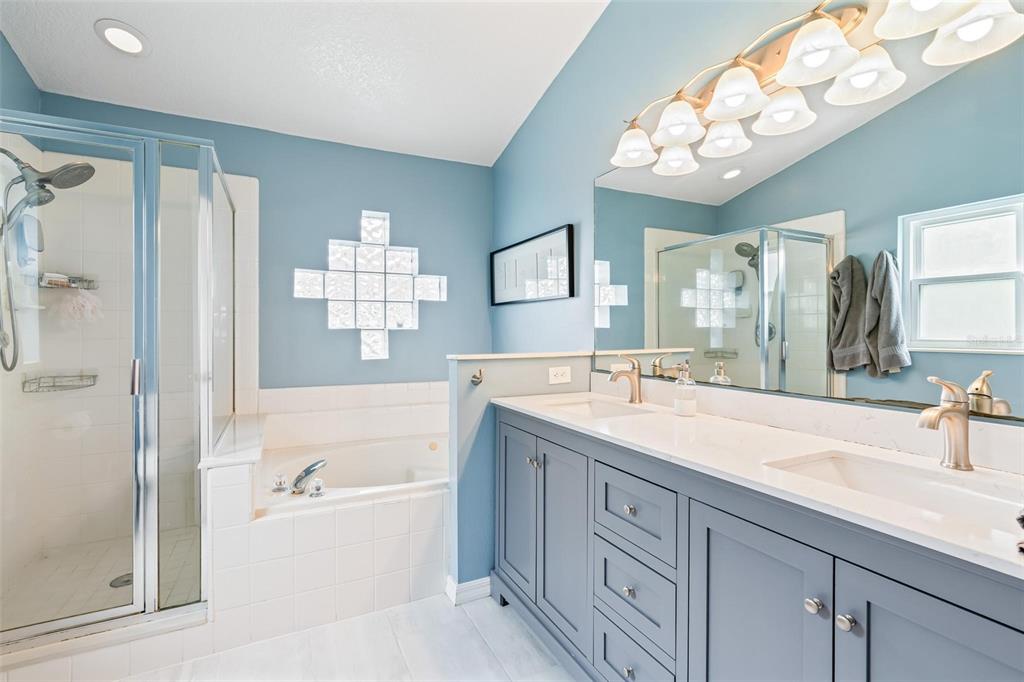 325 Longshadows Court Ocoee, FL 34761 - Photo 15 of 34 a bathroom with a sink double vanity granite tub shower and a mirror