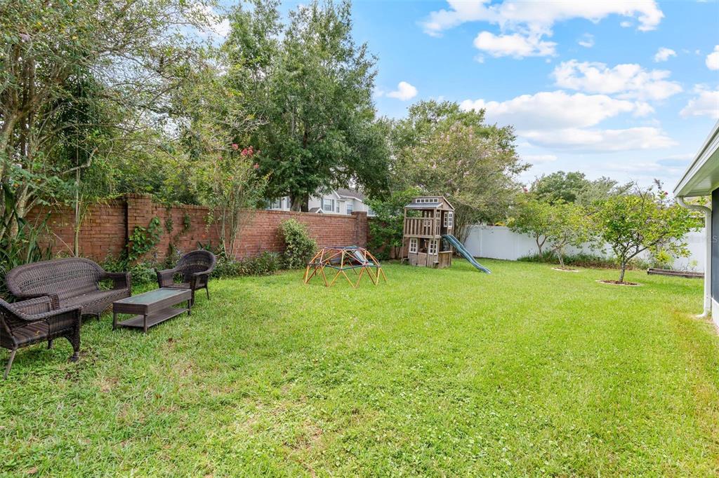 325 Longshadows Court Ocoee, FL 34761 - Photo 24 of 34 a view of a backyard with table and chairs and potted plants and large trees