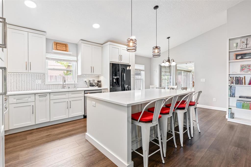325 Longshadows Court Ocoee, FL 34761 - Photo 7 of 34 a kitchen with a dining table chairs sink and cabinets